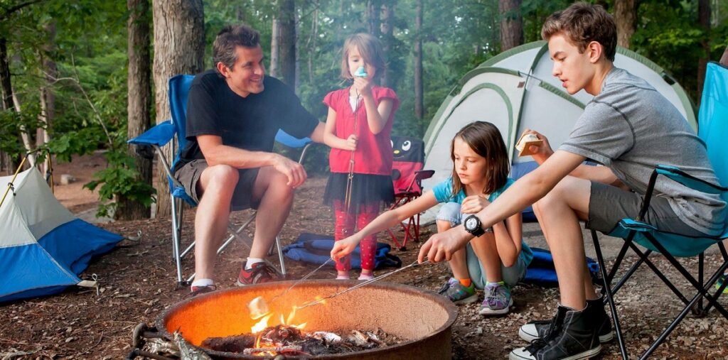 Family camping with kids roasting marshmallows at a Minnesota campsite – outdoor gear rentals